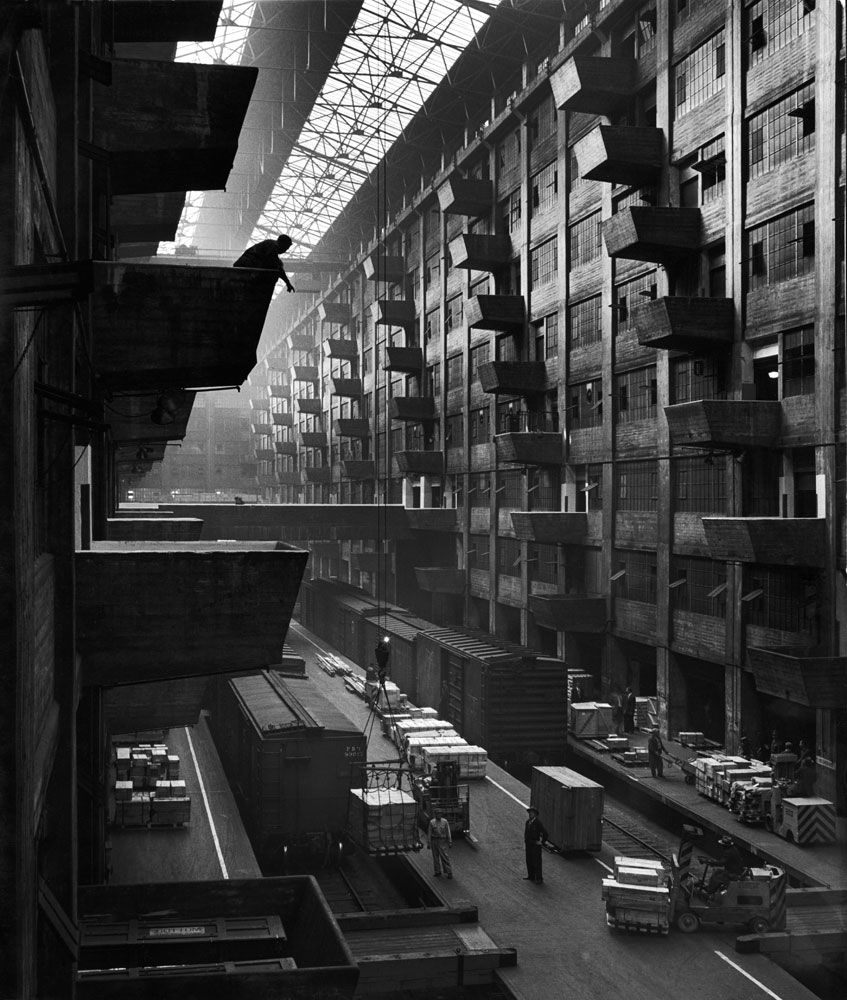 Off-loaded freight front box cars are hoisted up to jutting loading platforms at Brooklyn Army Terminal in October 1949.