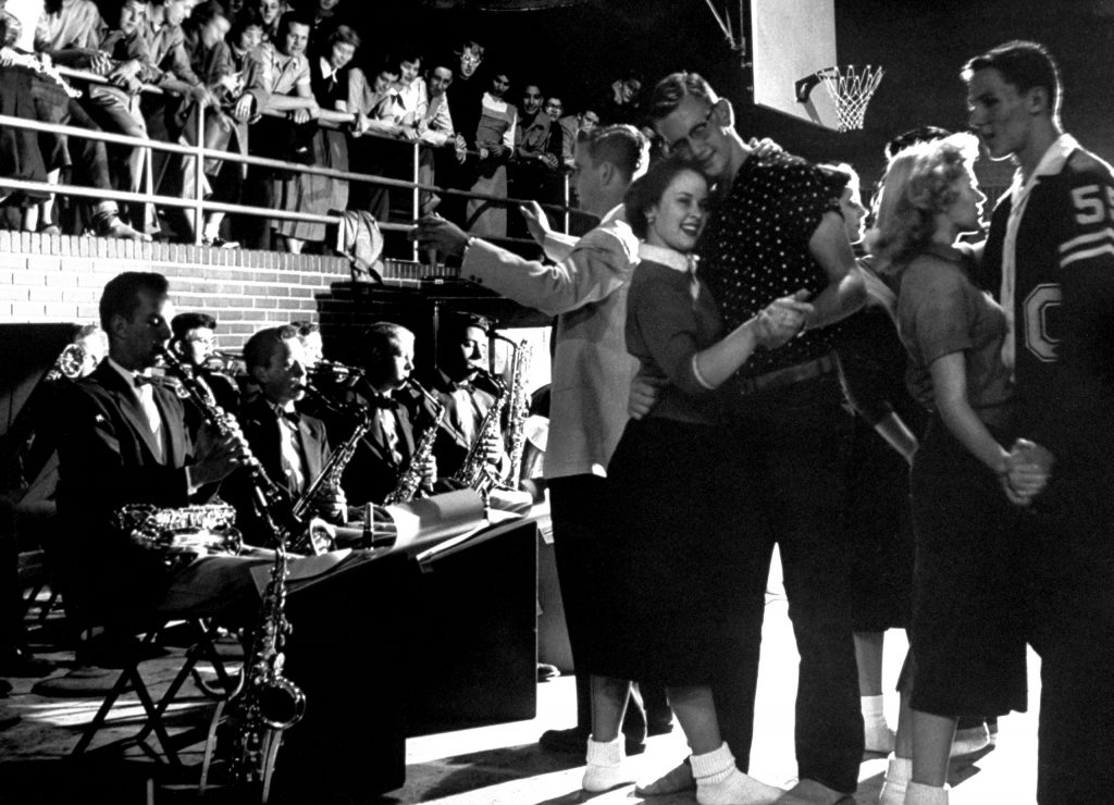 In aura of fun and well-being, students dance in gym of Carlsbad's high school at weekly "Sock Hop" to music of a 12-piece student band.