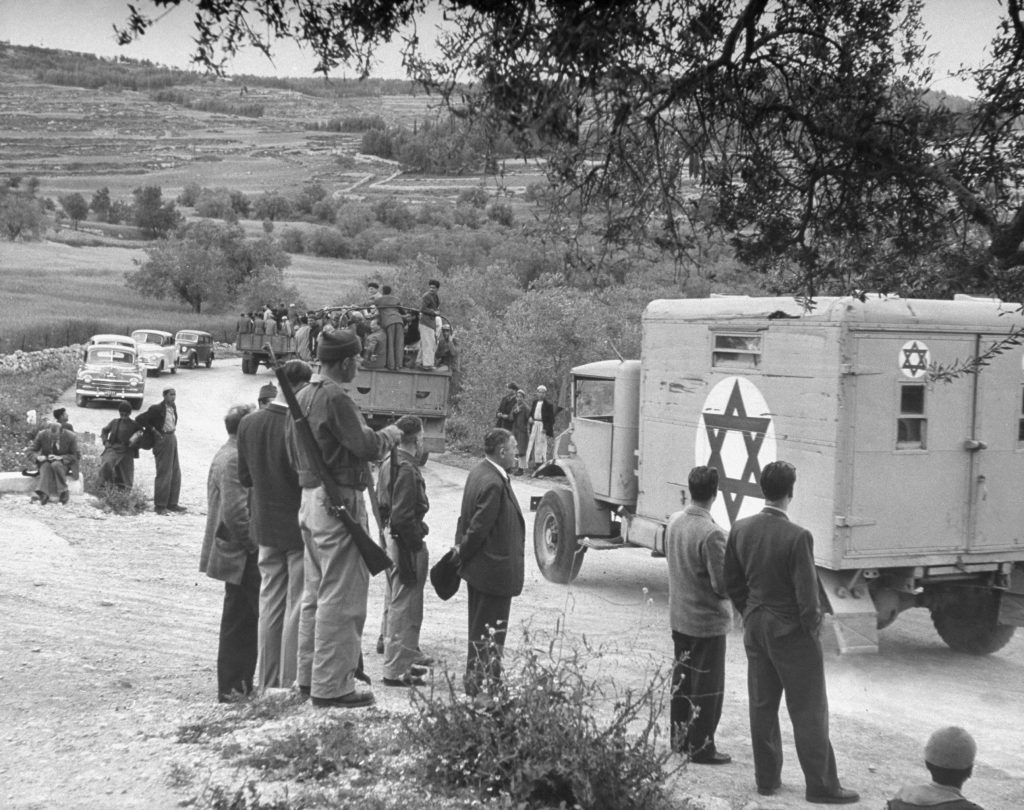 Armed forces of new state are built on Haganah militia. Members are shown here riding trucks down Jerusalem-Tel Aviv highway to go into action near Bab el Wad.