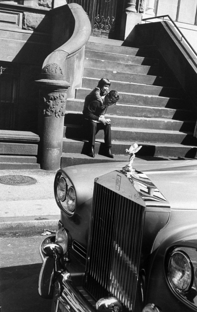 Tracy demands a piggy-back ride from her father. Sammy's Rolls-Royce is parked at the curb. This is one of his four cars among them a Mustang and a Cadillac with bar, TV, stereo and two telephones.