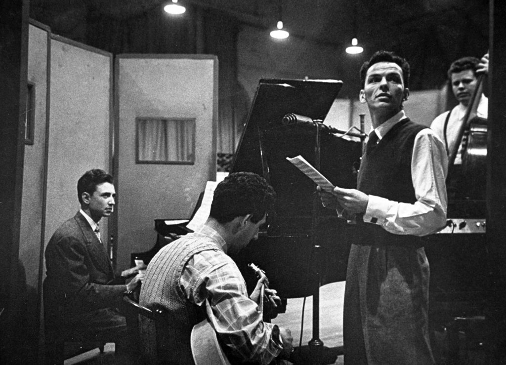 Frank Sinatra and musicians in studio during recording session at CBS.