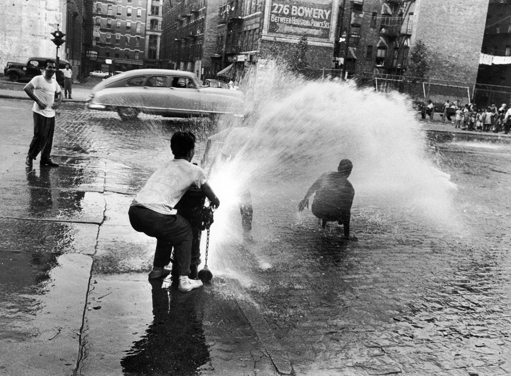 Children playing in water during a heat wave in New York City, 1953.