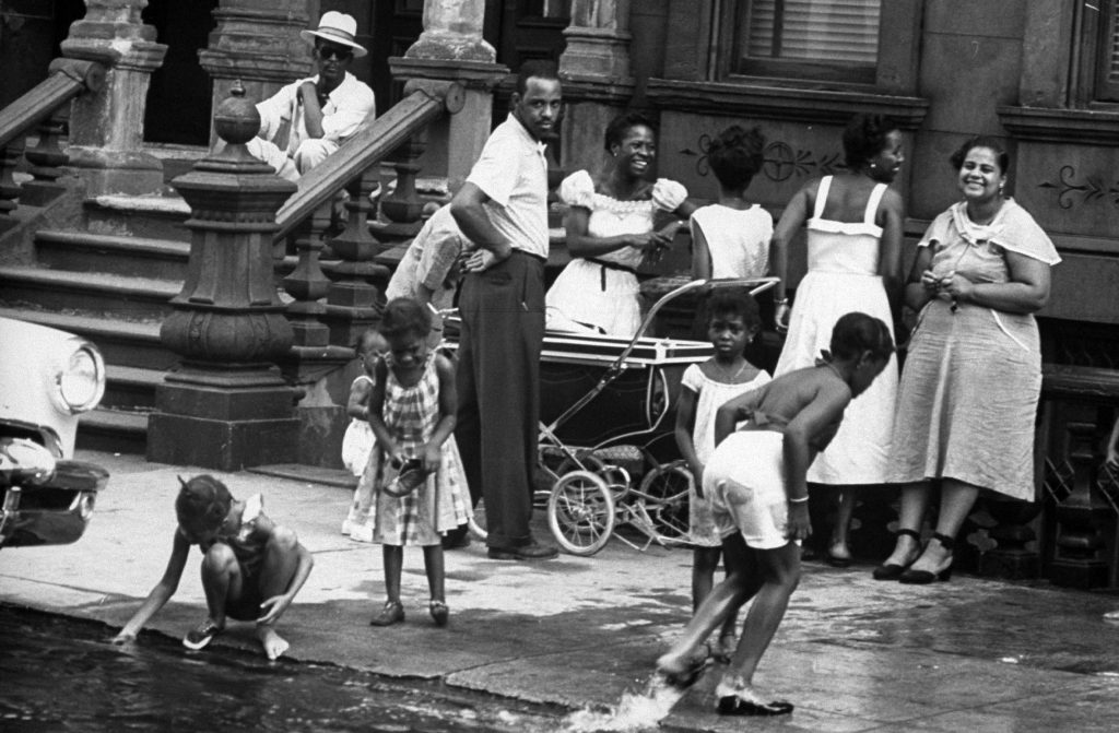 People spending time outdoors during an ongoing heatwave during the summer of 1953 in New York City.