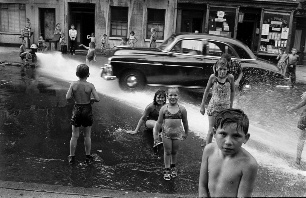 Children playing in water during a heat wave in New York City, 1953.