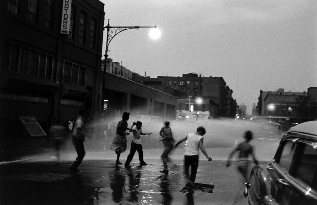 Children playing in water during a heat wave in New York City, 1953.