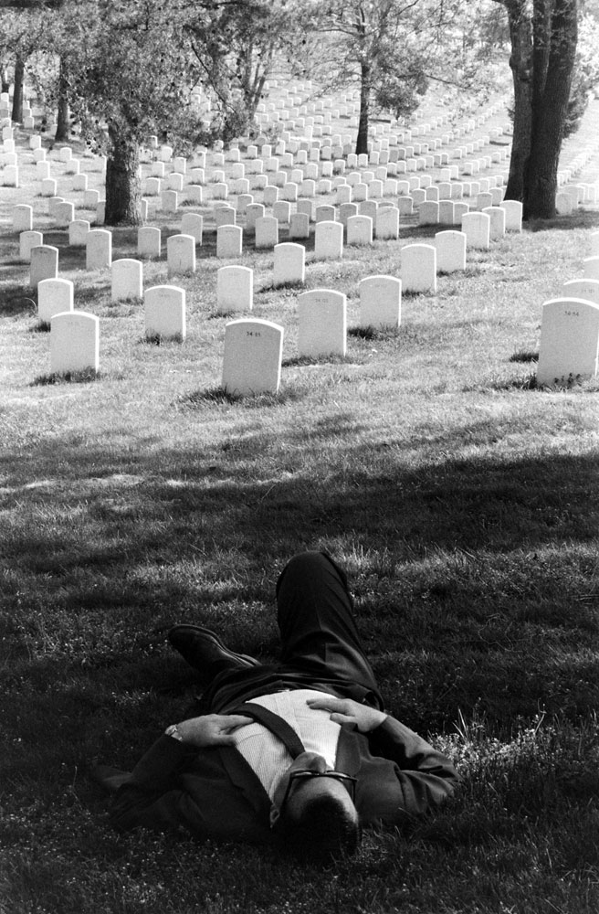 A man rests in the shade at Arlington National Cemetery, 1965.