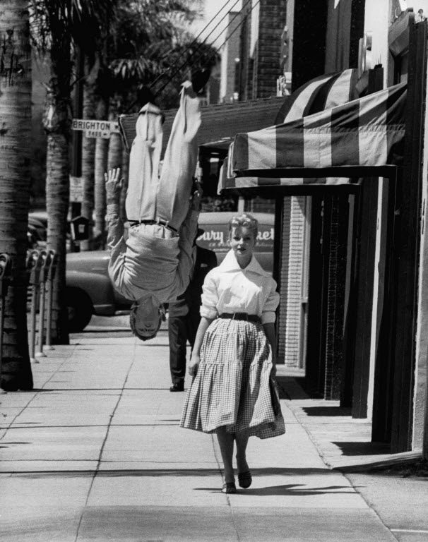 Acrobat and actor, Russ Tamblyn doing a flip on the sidewalk with starlet Venetia Stevenson. (Photo by Allan Grant/The LIFE Picture Collection © Meredith Corporation).