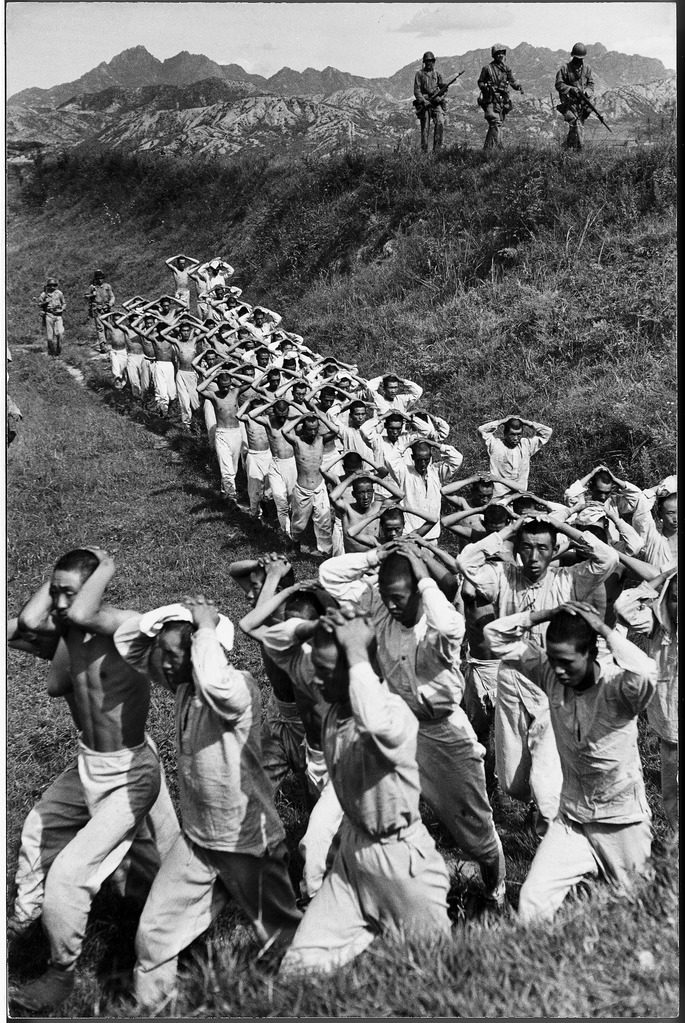 Communist prisoners stripped down to their underwear are marched to the rear by Marine guards. (Photo by Carl Mydans/The LIFE Picture Collection © Meredith Corporation)