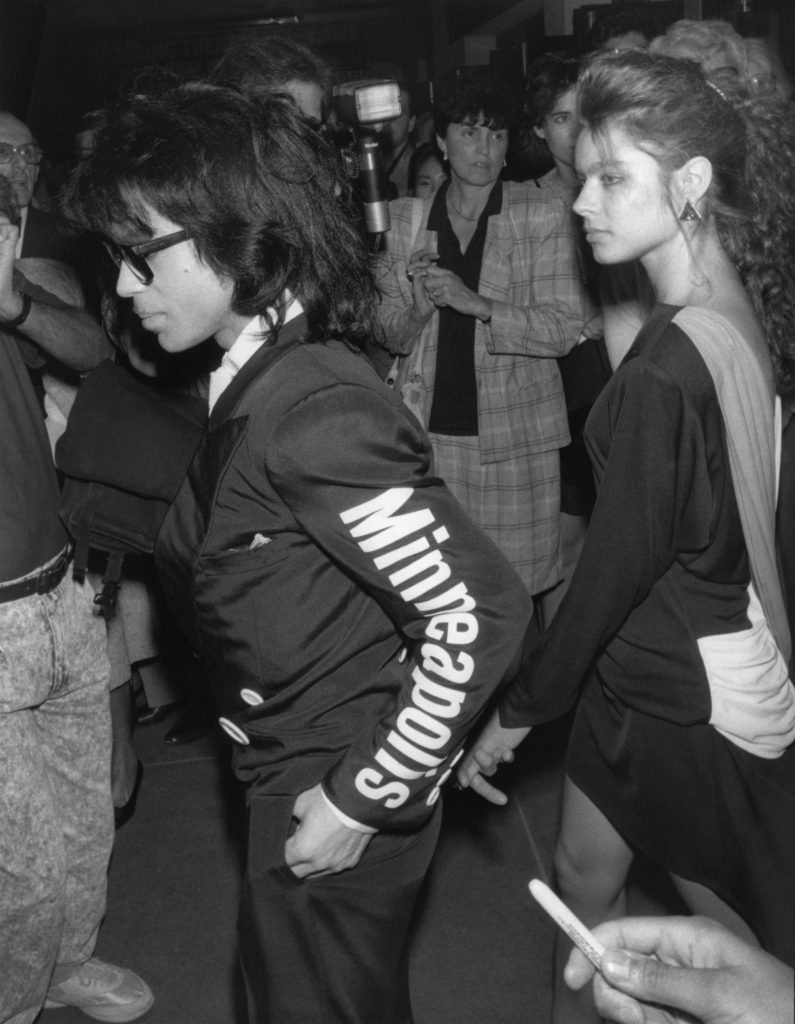 Musician Prince and an unidentified girlfriend are attending "M Butterfly" on Broadway. He is wearing a jacket with Minneapolis printed on the sleeve which is trademarked for his "Love Sexy 88 tour". New York, NY, September 23, 1988.